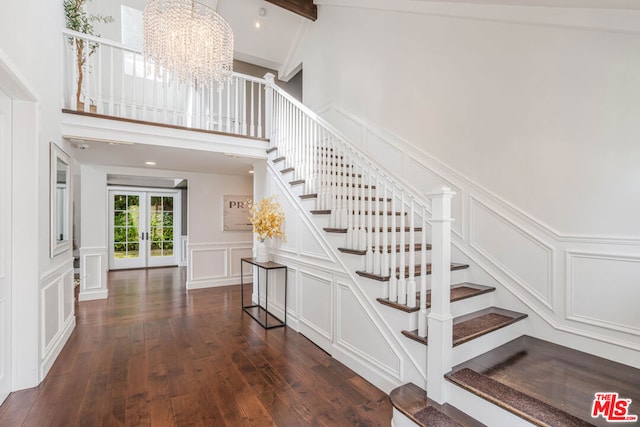 staircase featuring wood-type flooring, french doors, beamed ceiling, and a notable chandelier