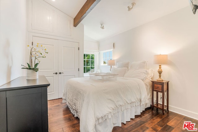 bedroom with a closet and vaulted ceiling with beams