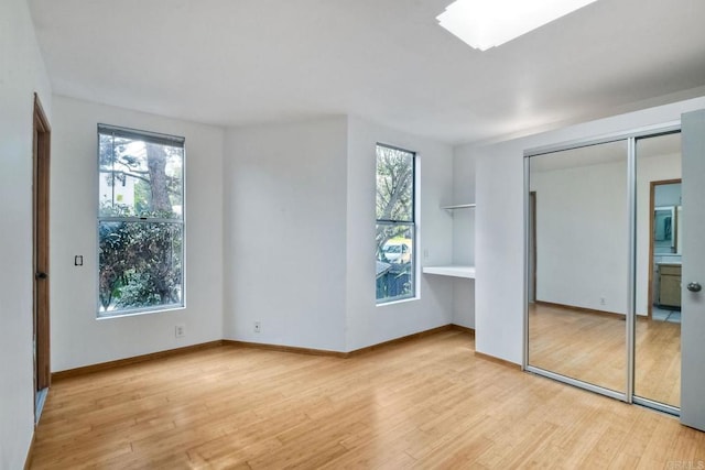 unfurnished bedroom with multiple windows and light hardwood / wood-style flooring