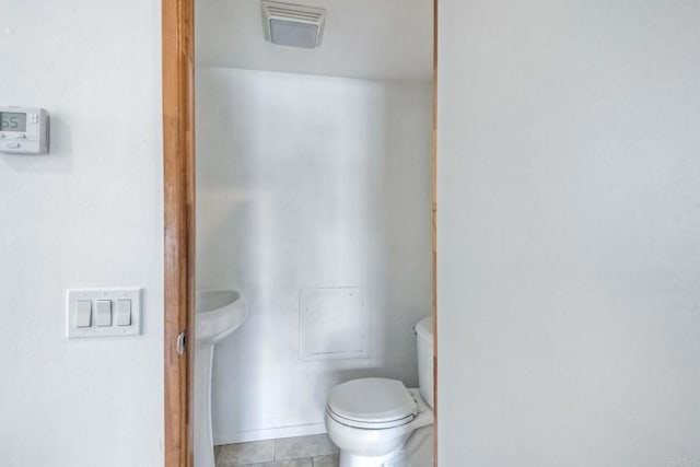 bathroom with toilet and tile patterned flooring