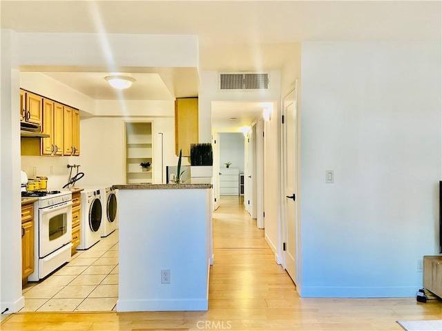 kitchen with white range with gas stovetop, separate washer and dryer, and light wood-type flooring