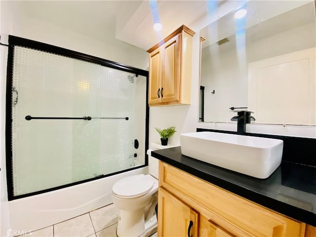 full bathroom with tile patterned floors, combined bath / shower with glass door, vanity, and toilet