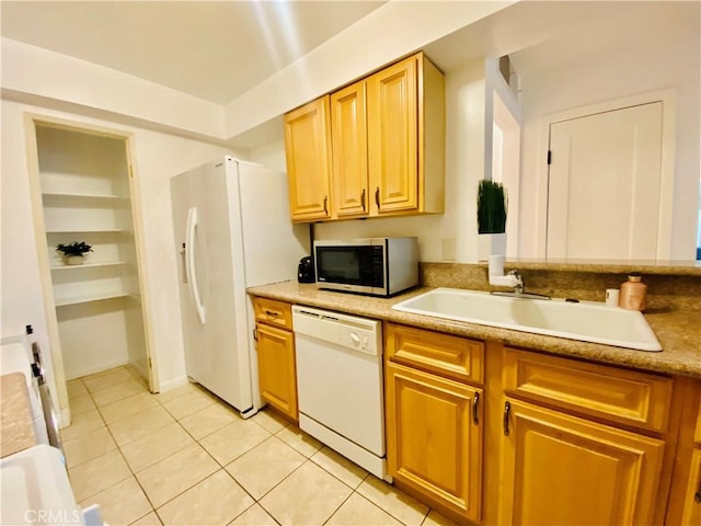 kitchen with sink, white appliances, and light tile patterned flooring