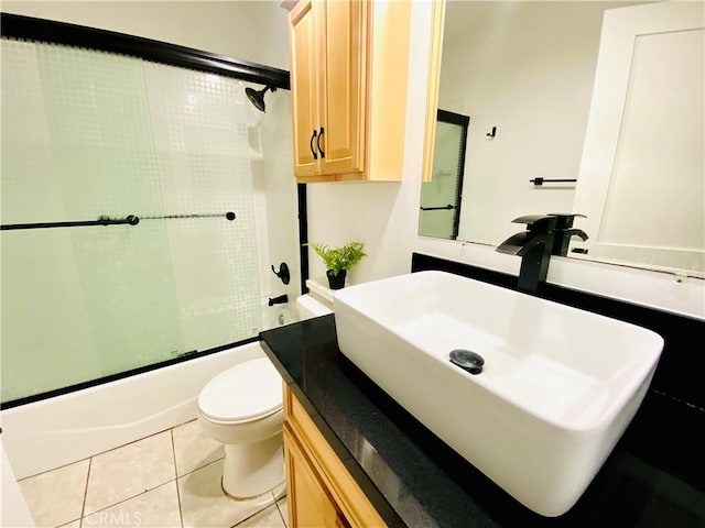 full bathroom with toilet, enclosed tub / shower combo, vanity, and tile patterned floors