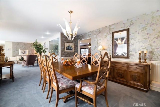 dining area featuring a notable chandelier and dark carpet