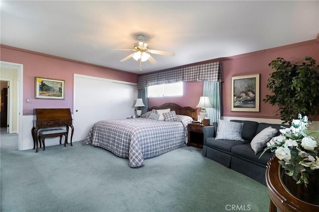 carpeted bedroom featuring ceiling fan and ornamental molding