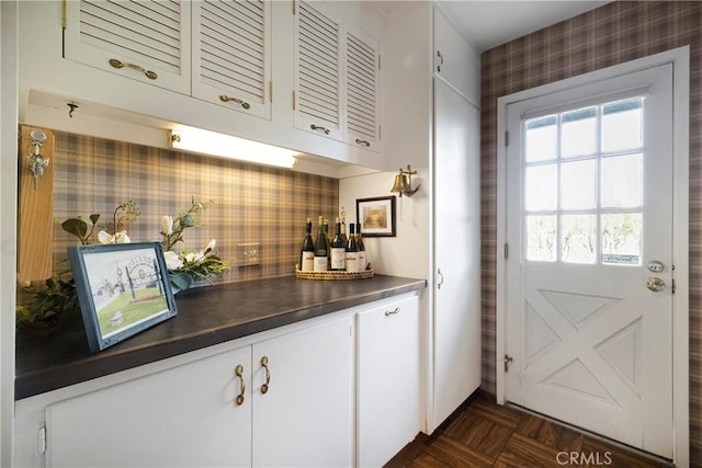 kitchen with white cabinets, dark parquet floors, and backsplash