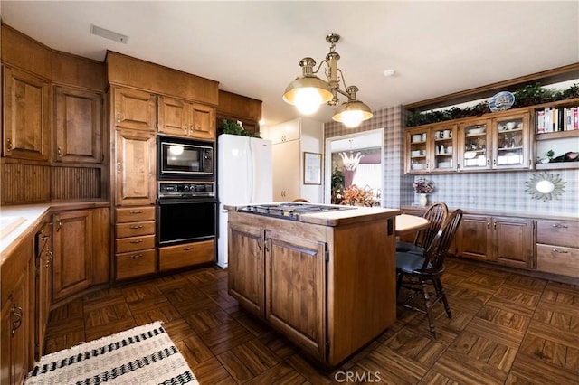 kitchen featuring black appliances, decorative light fixtures, dark parquet floors, and a center island