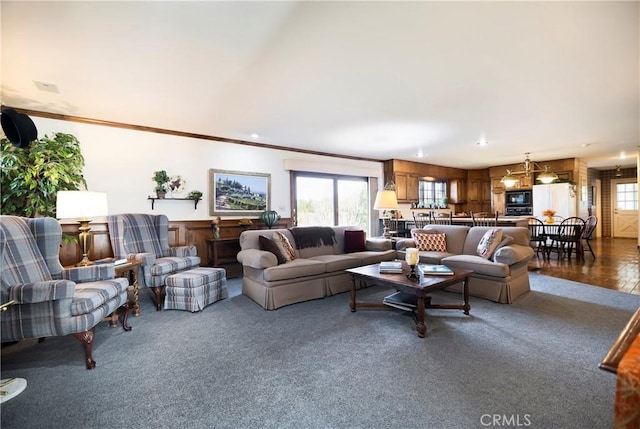 living room featuring carpet floors, crown molding, and a chandelier