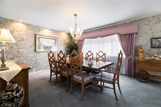 dining room with dark colored carpet and a chandelier