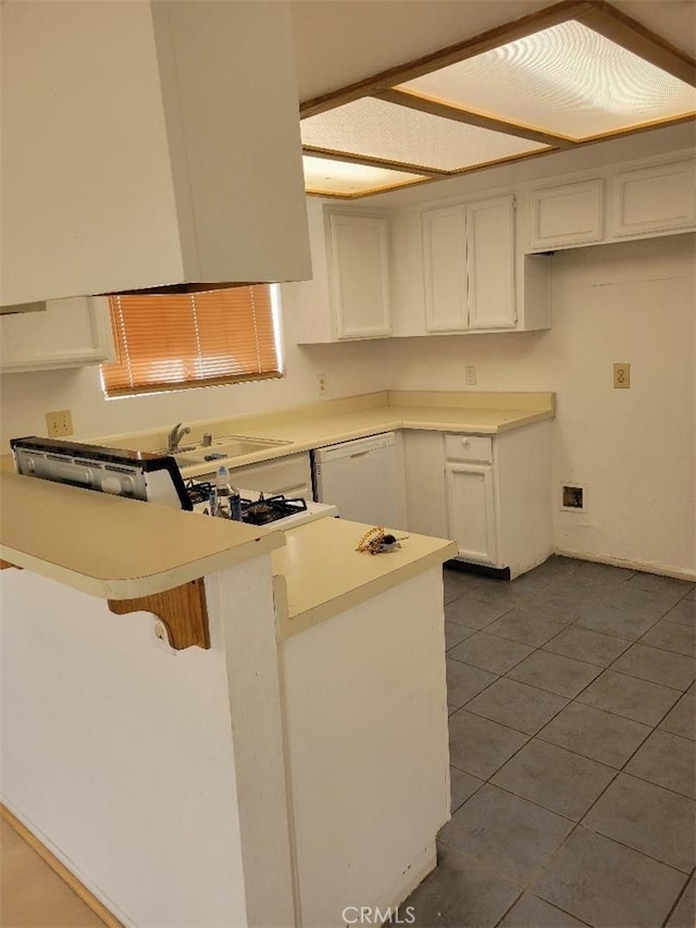 1217 Lill Hill Dr, Needles, CA 92363 - kitchen with white dishwasher, a peninsula, white cabinetry, dark tile patterned floors, and light countertops