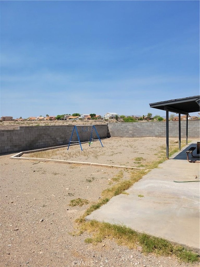 1217 Lill Hill Dr, Needles, CA 92363 - fenced backyard featuring a playground and a patio area