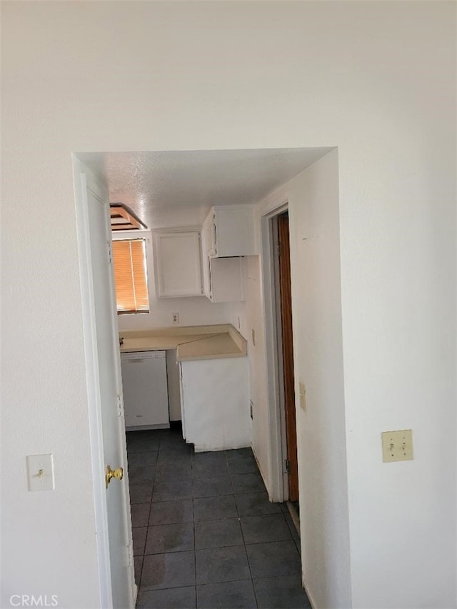 1217 Lill Hill Dr, Needles, CA 92363 - kitchen featuring white dishwasher, white cabinets, dark tile patterned floors, and light countertops