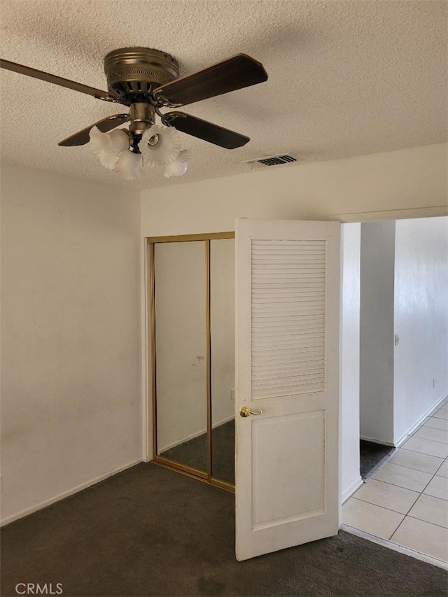 1217 Lill Hill Dr, Needles, CA 92363 - unfurnished bedroom featuring a textured ceiling, a closet, a ceiling fan, and carpet