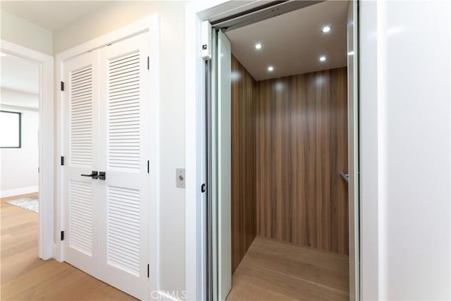 corridor featuring light hardwood / wood-style flooring and elevator