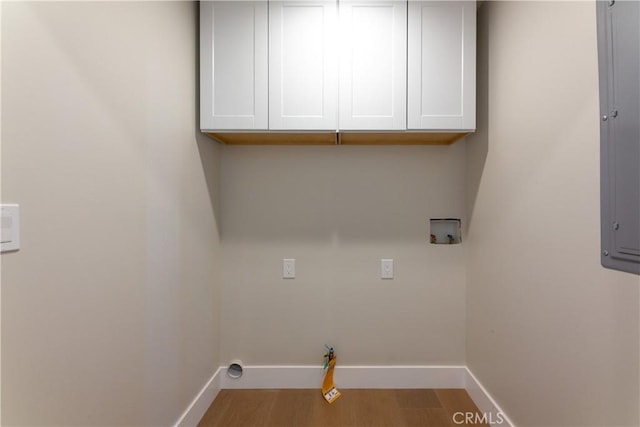 clothes washing area with hardwood / wood-style floors, washer hookup, gas dryer hookup, and cabinets