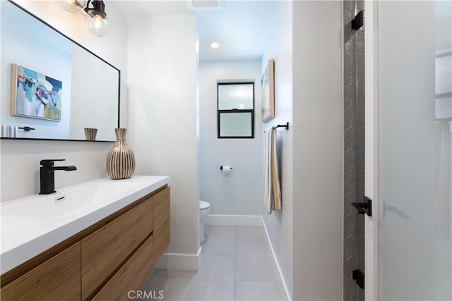 bathroom with toilet, vanity, and tile patterned flooring