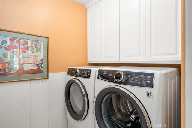 clothes washing area featuring cabinets and washing machine and clothes dryer