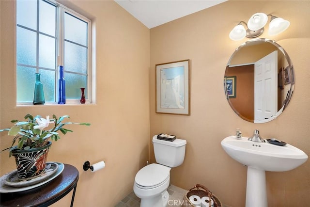 bathroom featuring toilet, a wealth of natural light, and tile patterned flooring