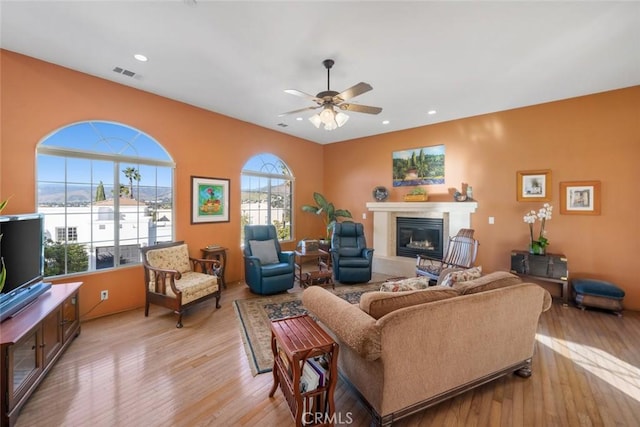 living room featuring ceiling fan, a healthy amount of sunlight, and light wood-type flooring