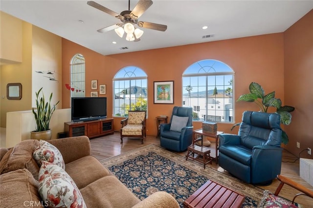 living room featuring ceiling fan and dark hardwood / wood-style floors