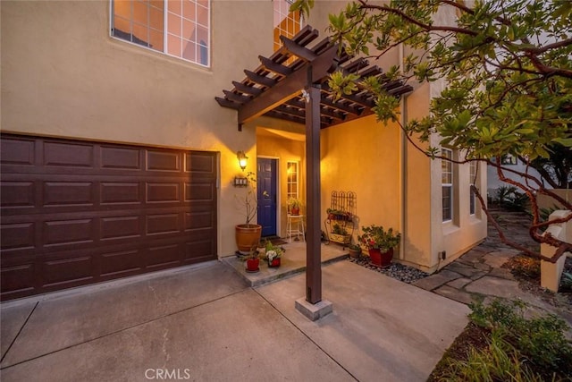 entrance to property with a pergola and a garage