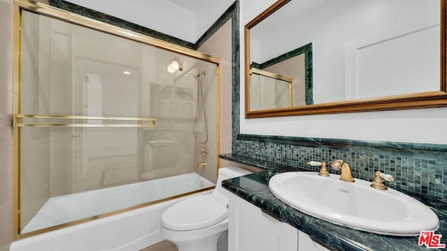 full bathroom featuring combined bath / shower with glass door, tasteful backsplash, toilet, and vanity