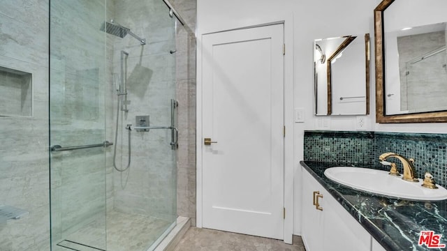 bathroom featuring a shower with door and vanity