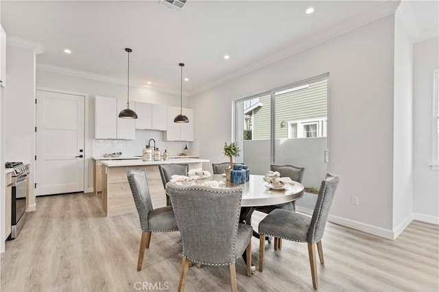 dining space featuring crown molding and light hardwood / wood-style flooring