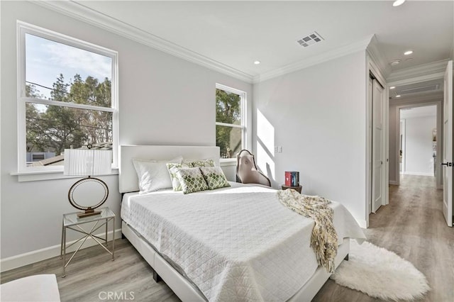 bedroom featuring crown molding and light wood-type flooring