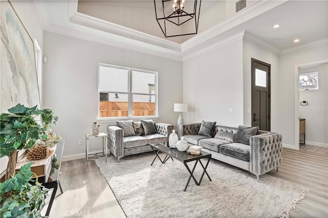 living room featuring ornamental molding, hardwood / wood-style floors, and a chandelier