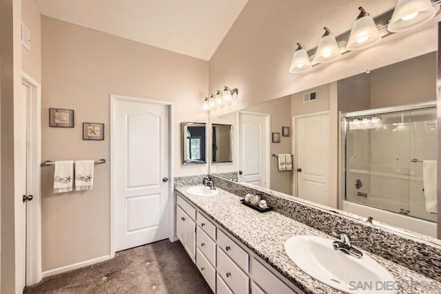 bathroom featuring vanity, vaulted ceiling, and shower / bath combination with glass door