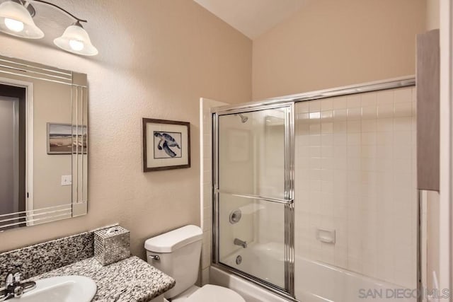 full bathroom with vanity, lofted ceiling, shower / bath combination with glass door, and toilet