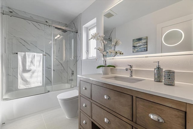 full bathroom with tile patterned floors, combined bath / shower with glass door, vanity, and toilet