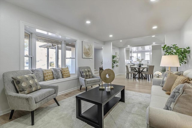 living room with a wealth of natural light and light hardwood / wood-style flooring