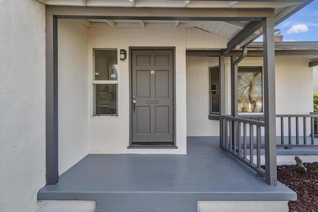 view of exterior entry with a porch