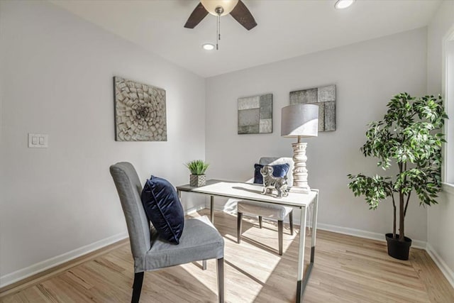 home office with ceiling fan and light hardwood / wood-style flooring