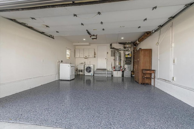 garage featuring sink, gas water heater, washing machine and dryer, and a garage door opener