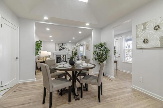 dining room featuring light hardwood / wood-style flooring and vaulted ceiling