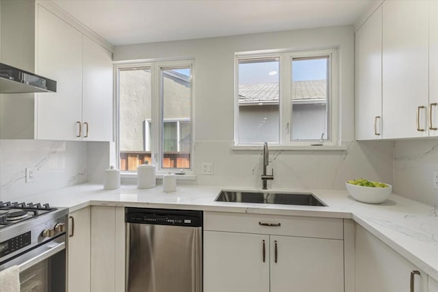 kitchen with sink, white cabinetry, appliances with stainless steel finishes, and wall chimney exhaust hood