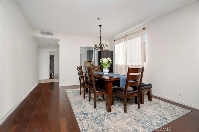 dining room with a notable chandelier and dark wood-type flooring