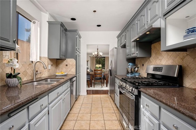 kitchen with appliances with stainless steel finishes, gray cabinetry, light tile patterned flooring, a chandelier, and sink