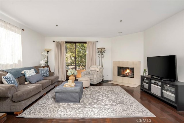 living room with dark hardwood / wood-style floors and a tile fireplace