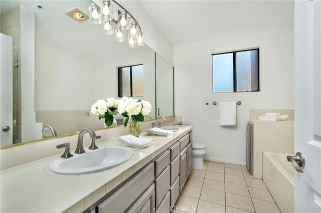 bathroom with a healthy amount of sunlight, tile patterned floors, toilet, and vanity