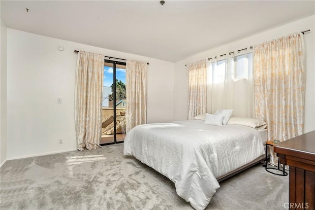 bedroom with multiple windows, carpet flooring, and access to outside