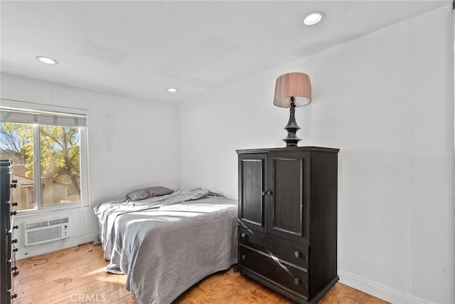 bedroom with light hardwood / wood-style floors and a wall mounted AC