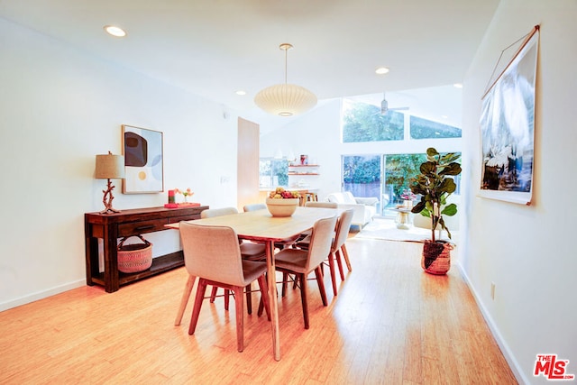 dining room featuring vaulted ceiling and light hardwood / wood-style floors