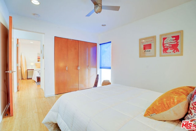 bedroom featuring light hardwood / wood-style floors, a closet, and ceiling fan