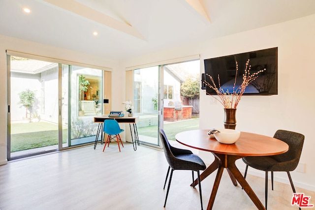 dining room featuring light hardwood / wood-style floors and vaulted ceiling