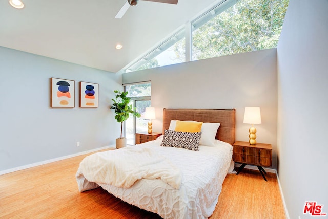 bedroom with hardwood / wood-style flooring, vaulted ceiling, and ceiling fan